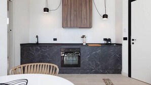 A modern kitchen with a dark marble countertop, a built-in oven, and pendant lighting. - Apartment Ogliarola - Maina Country Resort - with pool, in Sicily (Cresta)