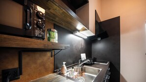 A modern kitchen with a stainless steel sink, wooden shelves, a microwave, and a built-in oven.