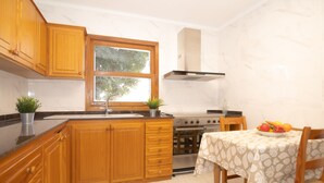 Una cocina con armarios de madera, una estufa, un fregadero y una ventana.