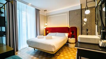 Une chambre d’hôtel avec un grand lit, une table de chevet, un bureau et une salle de bain.