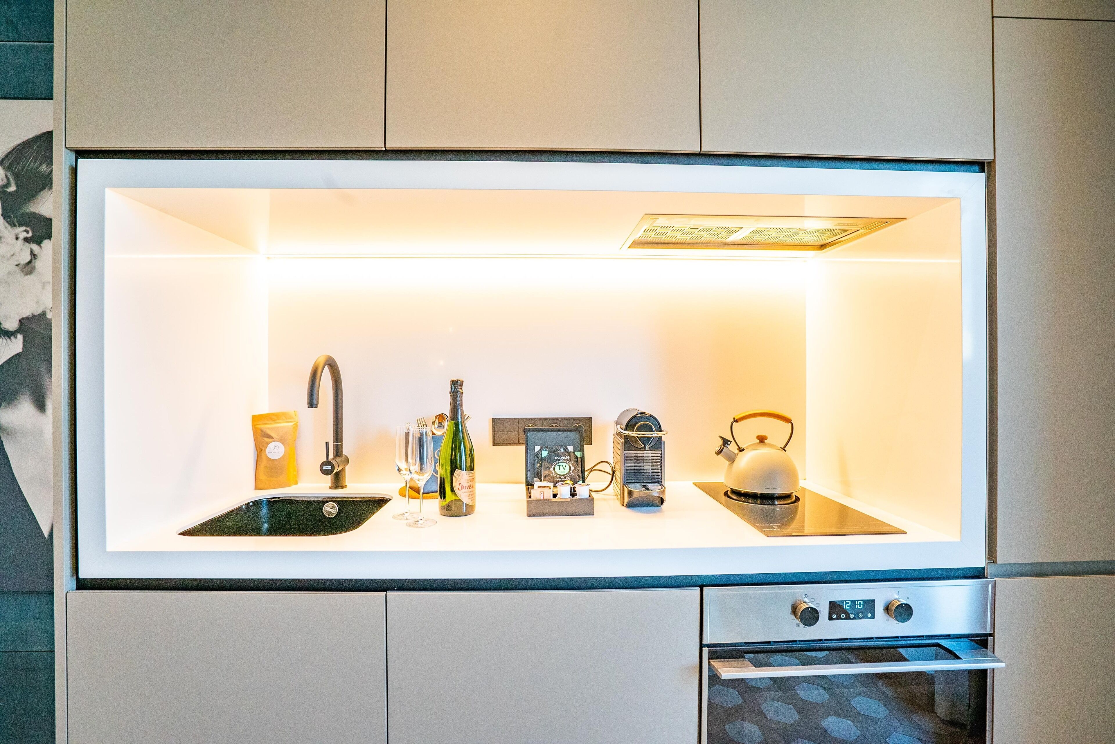 Una cocina moderna con refrigerador empotrado, un lavamanos y una estufa.