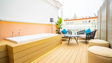 Ein modernes Badezimmer im Freien mit einem Holzbadezimmer-Möbel, einem weißen Waschbecken und einer Sitzecke mit Tisch und Stühlen.