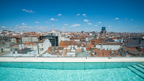 Vista de un paisaje urbano con una piscina en primer plano.