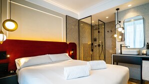 Una habitación de hotel con una cama grande, un escritorio con espejo y un baño con lavamanos.