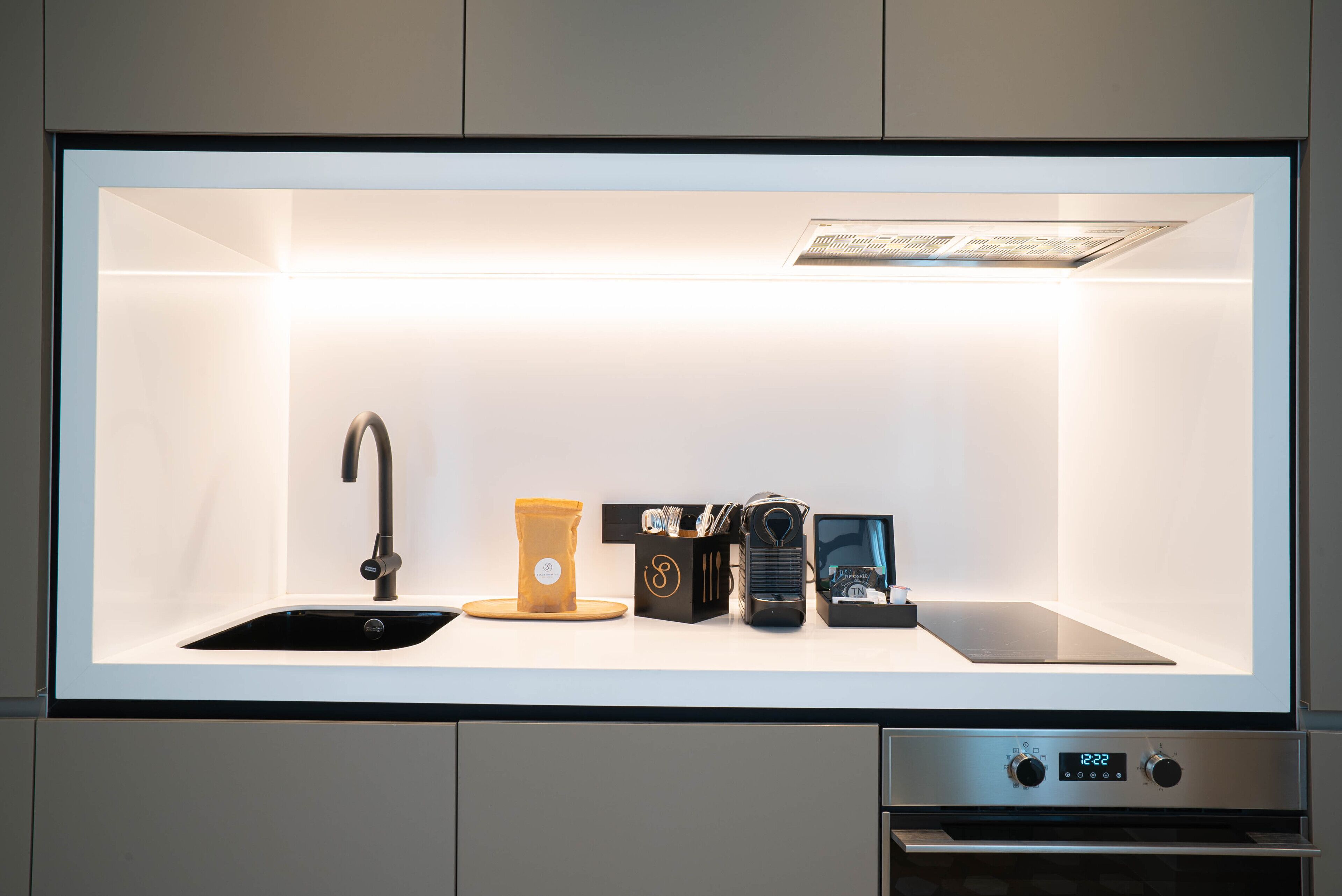 A modern kitchen with a built-in sink, a coffee machine, and a toaster.