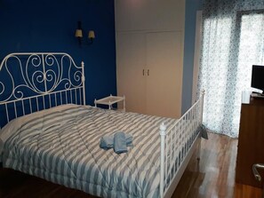 A bedroom with a bed, a nightstand, a wardrobe, and a television. - 2 Bed Flat - Sleeps 4 - Pets - Wifi (Thessaloniki)