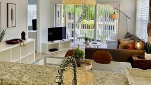 Une cuisine moderne dotée de plans de travail en granit, d’une cuisinière intégrée et d’un grand îlot central avec un évier.