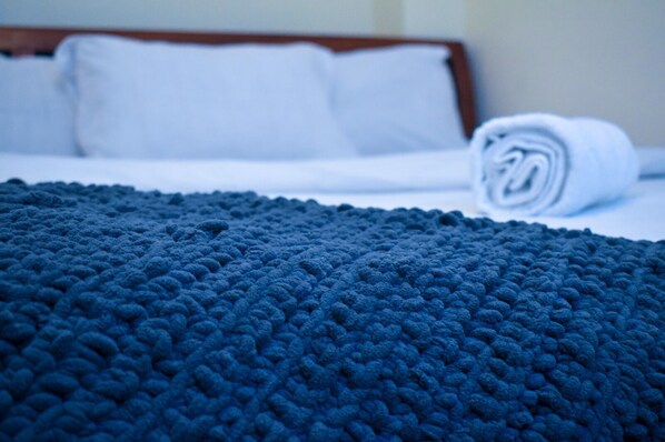 A neatly made bed with a folded blanket and pillows. - Dream house (Nairobi)
