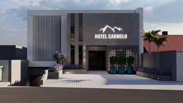 A modern hotel entrance with a prominent sign reading "HOTEL CARMELO".
