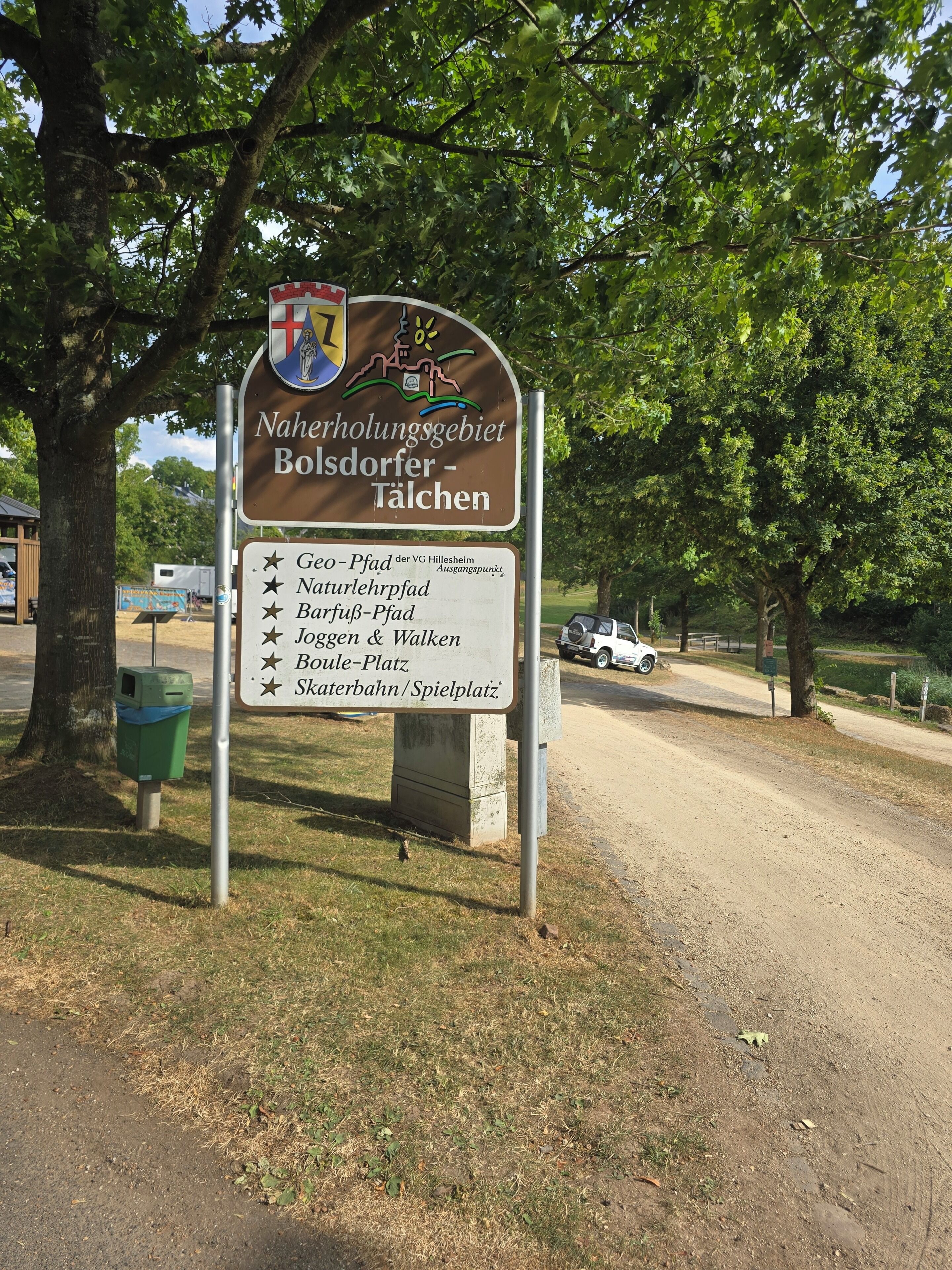 A signpost with a list of amenities including a nature trail, picnic area, and playground.