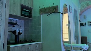 Une cuisine compacte avec des meubles en bois, un four à micro-ondes encastré et une petite fenêtre.