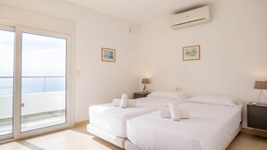 Et hotelværelse med to senge, en balkon og et klimaanlæg.