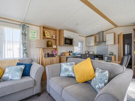 Un espacio habitable compacto con una sala, una pequeña cocina y una mesa de comedor.