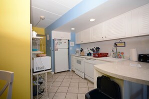 Kitchen features a refrigerator, oven, and dishwasher, with a countertop area for food preparation.