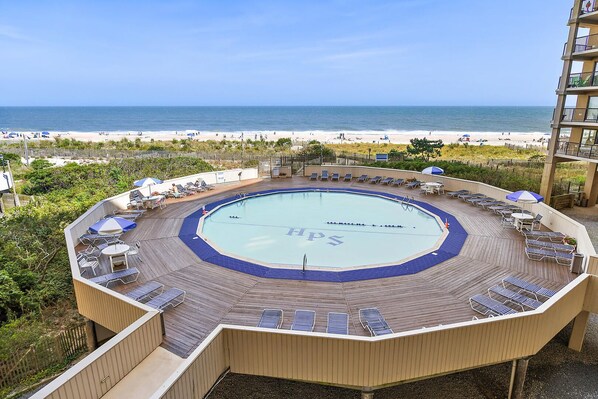 Relax by the pool with a panoramic view of the beach and ocean.