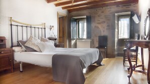 A bedroom with a bed, wooden floor, a desk, and a chair. - Large villa with pool near Santiago (Ames)