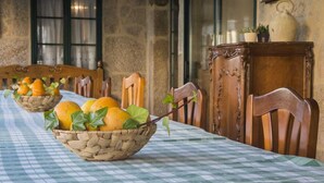 A dining table with a checkered tablecloth, wooden chairs, and baskets of fruit. - Large villa with pool near Santiago (Ames)