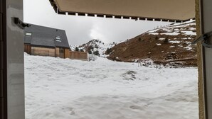 Paisaje nevado con un edificio y una montaña al fondo.