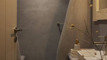 A modern bathroom with a grey shower, a white sink, and a mirror.