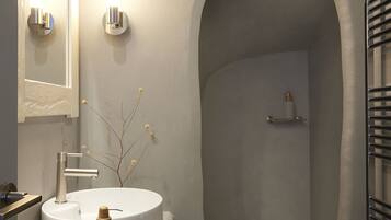 Une salle de bain moderne avec une baignoire sur pieds, un meuble-lavabo avec un miroir et un porte-serviettes.
