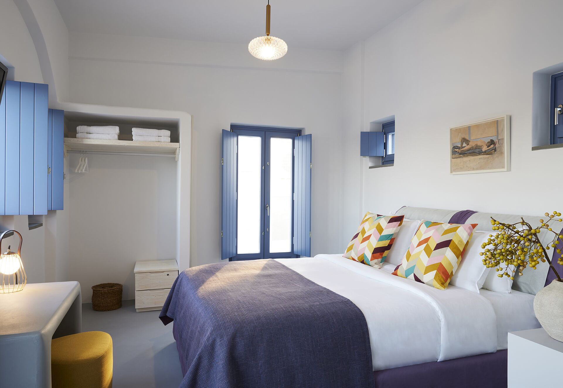 A bedroom with a bed, a desk, a chair, a wardrobe, and a window.