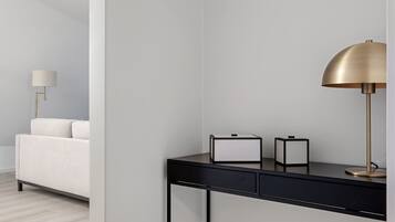 A modern, minimalist room with a black desk, a gold lamp, and a white sofa.