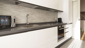 A modern kitchen with a built-in microwave, stainless steel sink, and a large window.