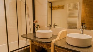 A modern bathroom with two round sinks, a large mirror, and a shower enclosure. - Les Gets, Luxury duplex apartment with Jacuzzi (Les Gets)