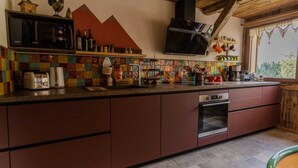 A kitchen with a wooden ceiling, a microwave, a toaster, and a stove. - Les Gets, Luxury duplex apartment with Jacuzzi (Les Gets)