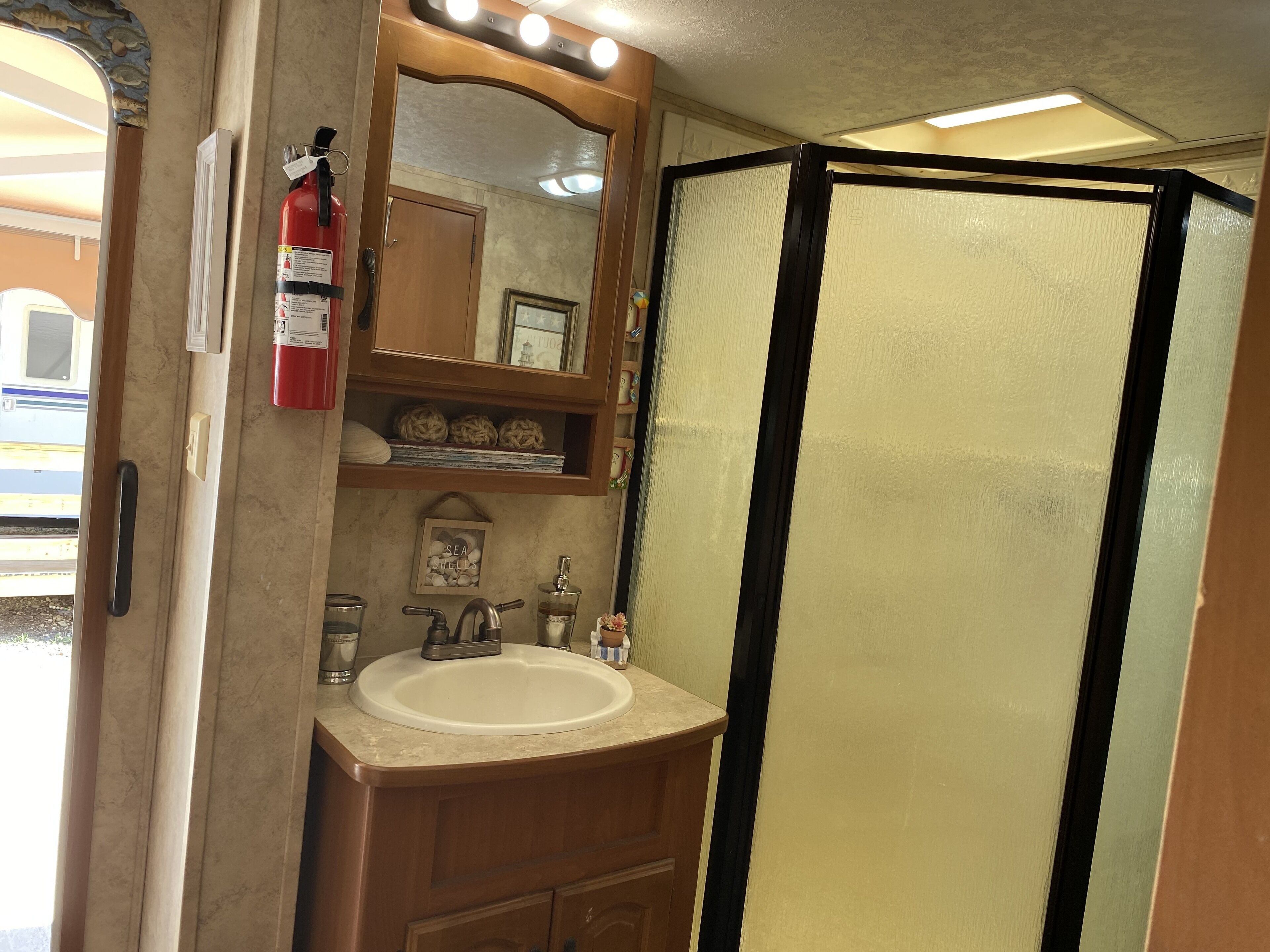 Baño con lavabo, espejo y cabina de ducha.