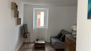 Un salon spacieux avec un plancher en bois, un canapé, une table basse et un meuble.