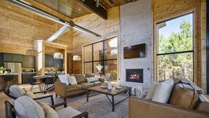 A modern log cabin interior with a living area, kitchen, and fireplace. - Sunlit Spaces • 6-Bunk Room • Big Porch Fun (Broken Bow)