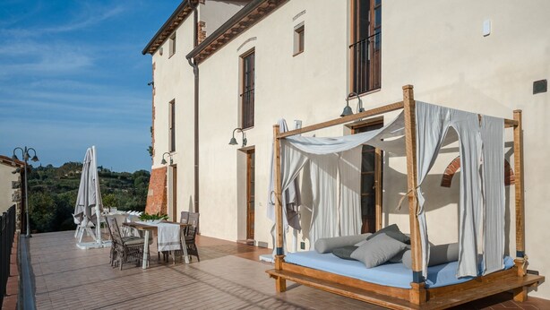 Una camera tradizionale con un letto a baldacchino, un tavolo con sedie e vista sulla campagna.