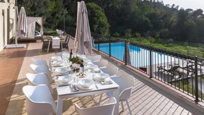 An outdoor dining area with a pool view, white tables and chairs, and umbrellas. - Casa Francia, Palaia, Pisa and Valdera (Palaia)