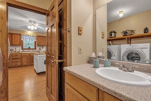 A kitchen with wooden cabinets, a countertop, and a ceiling fan.