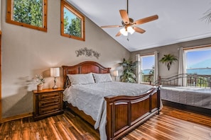A bedroom with a wooden bed, a ceiling fan, and a balcony with a view. - Roundtop Mountain Ridge 2 Bedroom Cabin by RedAwning (Sevierville)