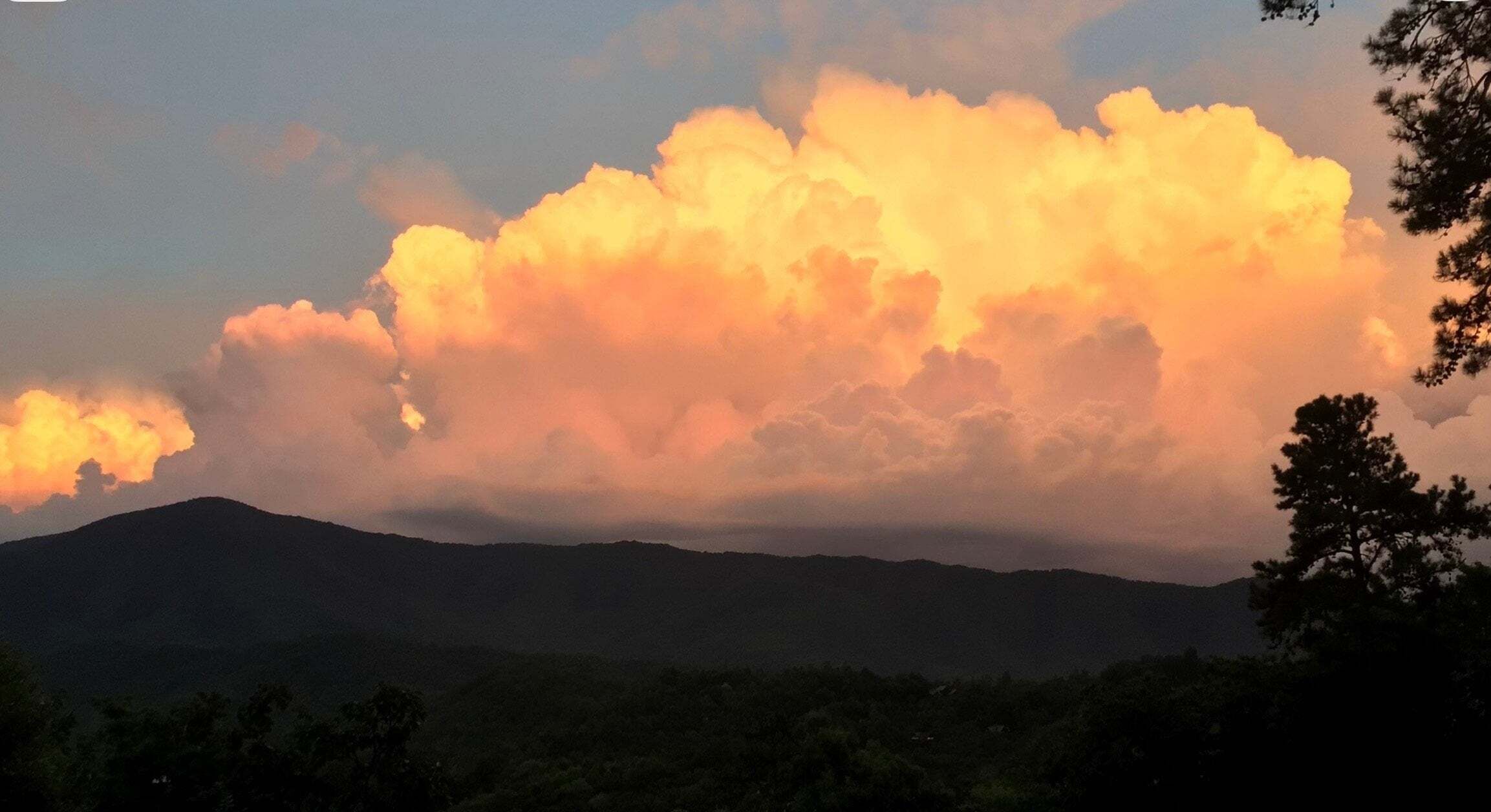 A mountain range with a large cloud formation in the sky.