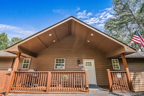 A building with a gabled roof, a wooden fence, and an American flag. - Roundtop Mountain Ridge 2 Bedroom Cabin by RedAwning (Sevierville)