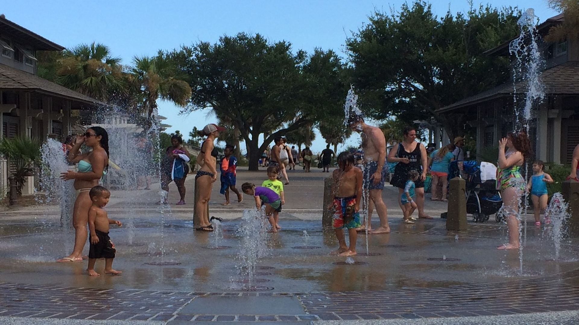 A public water fountain area with people enjoying the water.