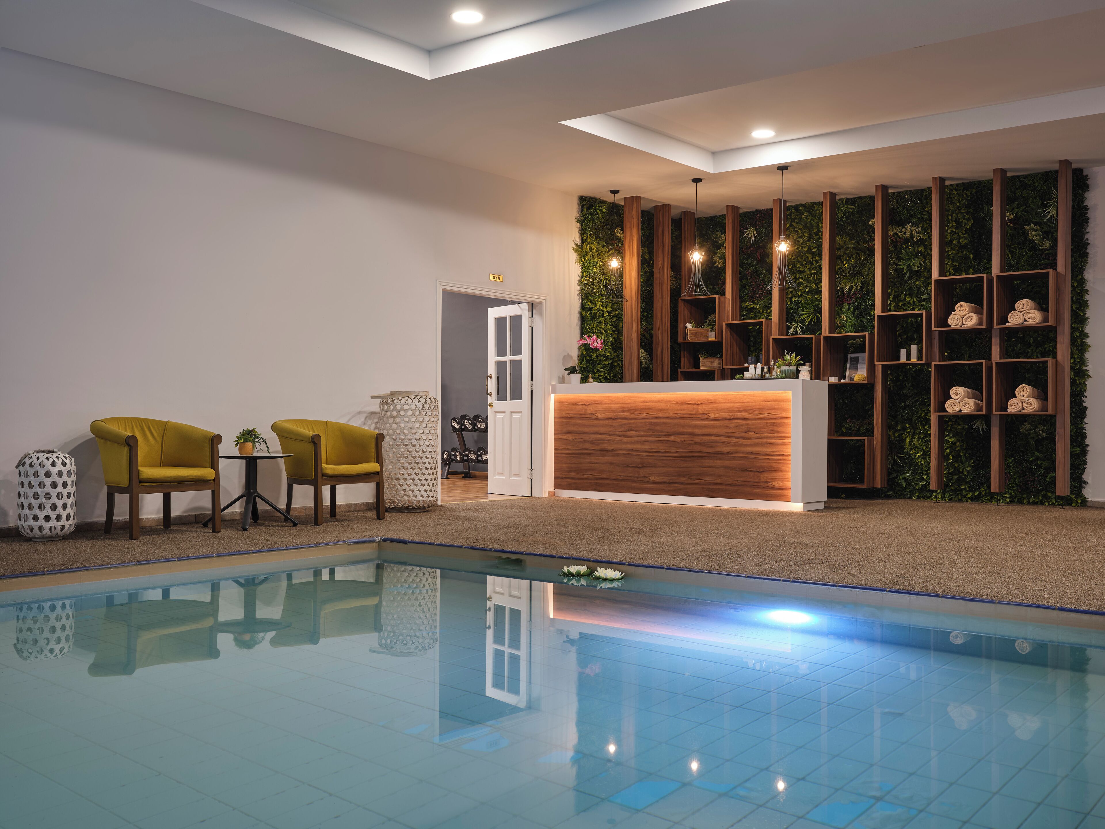 A reception area with a pool, reception desk, and two chairs.