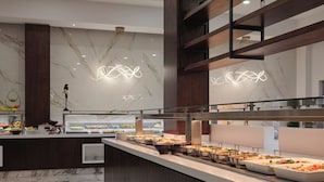 Ein modernes Buffet mit Marmorboden, Holzakzenten und zeitgemäßen Leuchten.