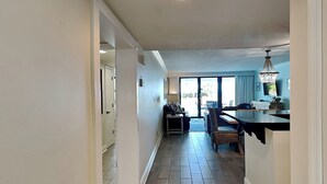 A spacious kitchen with a dining area, a large window, and a chandelier.