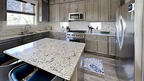 A kitchen with granite countertops, stainless steel appliances, and a central island. - View from the Top  -  4 Bikes, Golf Cart, Views! (Santa Rosa Beach)