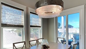 A dining area with a large table, chairs, and a chandelier. - View from the Top  -  4 Bikes, Golf Cart, Views! (Santa Rosa Beach)