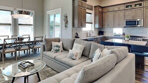 A modern kitchen with wooden cabinets, a built-in island, and stainless steel appliances. - View from the Top  -  4 Bikes, Golf Cart, Views! (Santa Rosa Beach)