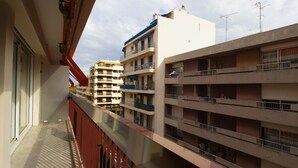 Un immeuble résidentiel à plusieurs étages, doté de balcons, d’un toit plat et surplombant un ciel dégagé.