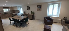 A modern kitchen with a dining area, a large window, and a radiator.