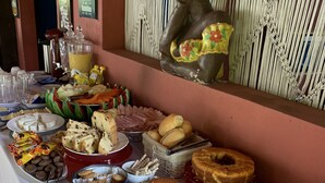 Una mesa de buffet con diversos alimentos, como pan, pasteles y salsas.