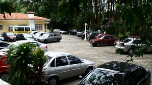Un estacionamiento con varios coches y un edificio con la leyenda 'ESCOLAR' al fondo.