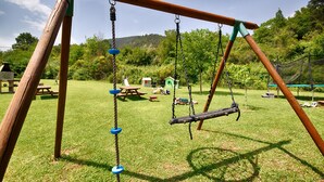A playground with swings and a picnic table.